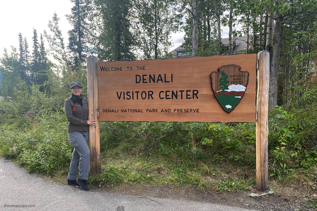Agnes next to wooden sign Denali Visitor Center during road trip from Anchorage to Fairbanks