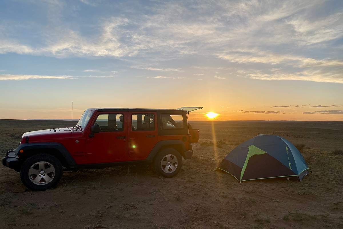 camping on BLM land in sunset: our red jeep and blue tent 
