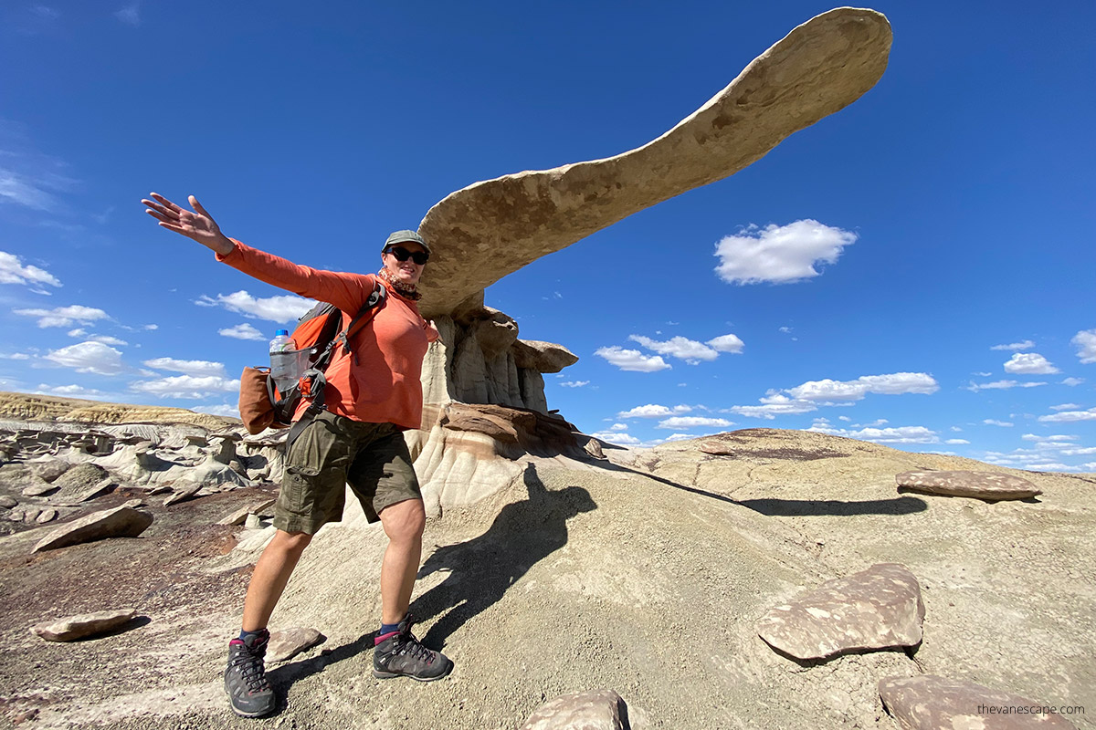 Agnes Stabinska, the author, in orange hoodie, green cap and hiking boots, with King of Wings rock formation in New Mexico. 