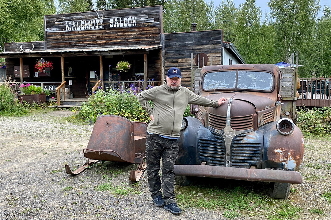Chris with old cars in front of Malemute Saloon in Ester Gold Camp