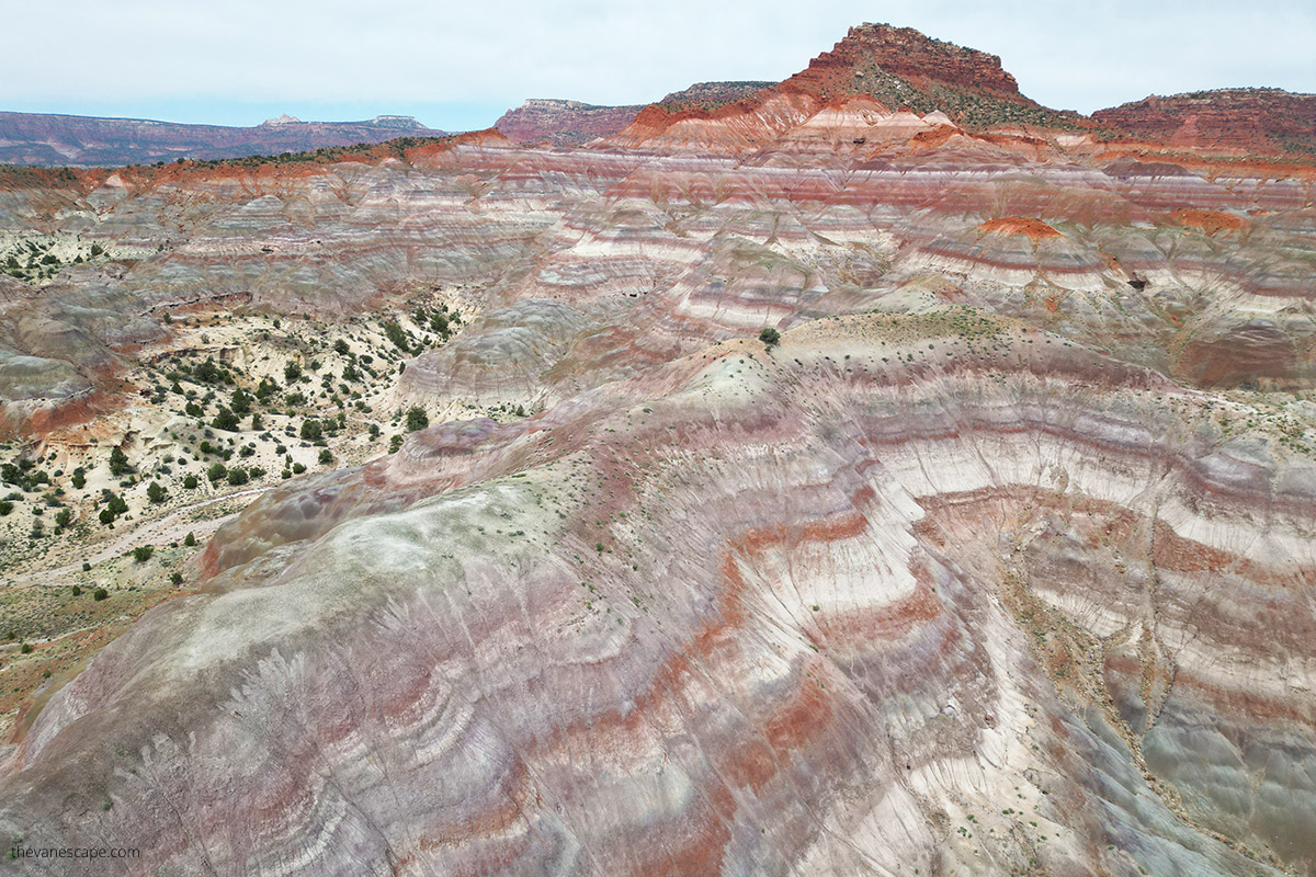 Aerial view of Paria Townsite in  Paria Rainbow Mountains. The rock's layers have many colors, shades of rust, red, purple, purple, gray, and white.