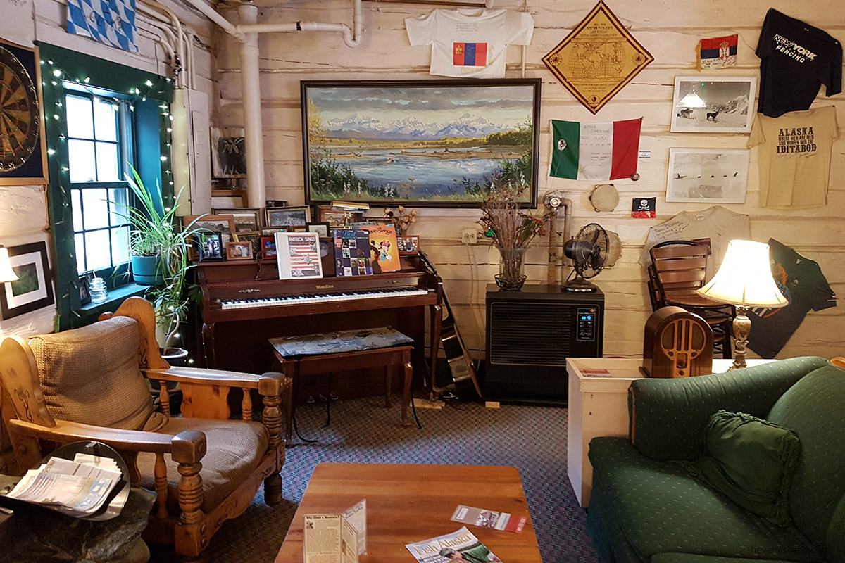 cozy interior of Talkeetna Roadhouse with armchair and piano, interesting place to stay near Denali