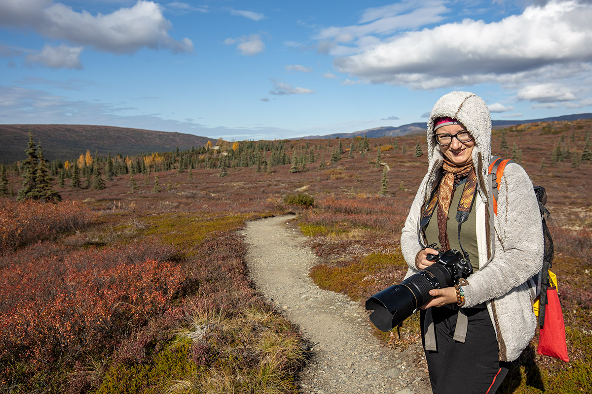 Agnes with her camera on hiking trail in Denali National Park in fall