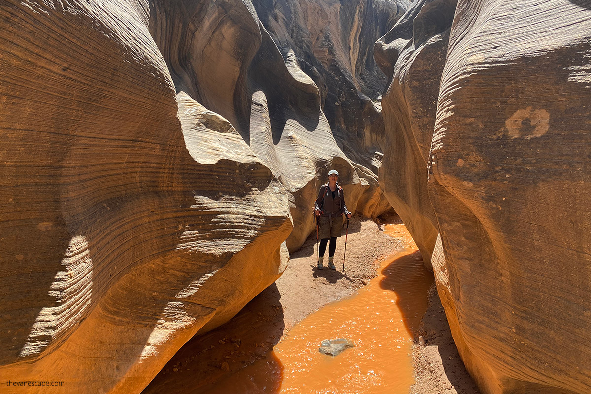 Agnes hiking among narrows and yellows walls of slot canyon