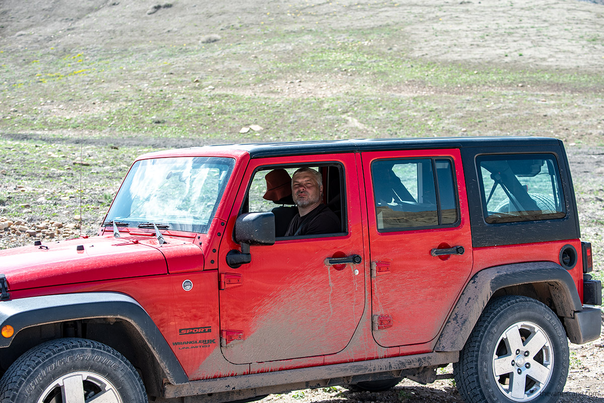 chris in his red jeep wrangler on the road