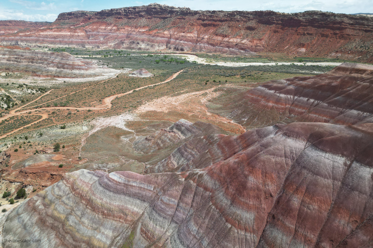 Aerial view (photo taken by drone) of Paria Rainbow Mountains rock layers, that have shades of rust, red, purple, purple, gray, and white