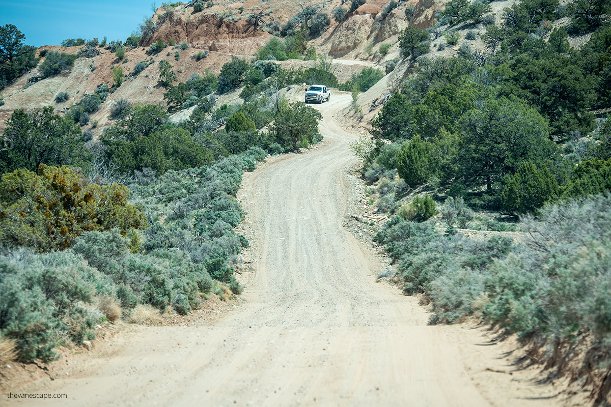 car driving cottonwood road with a lot of dust