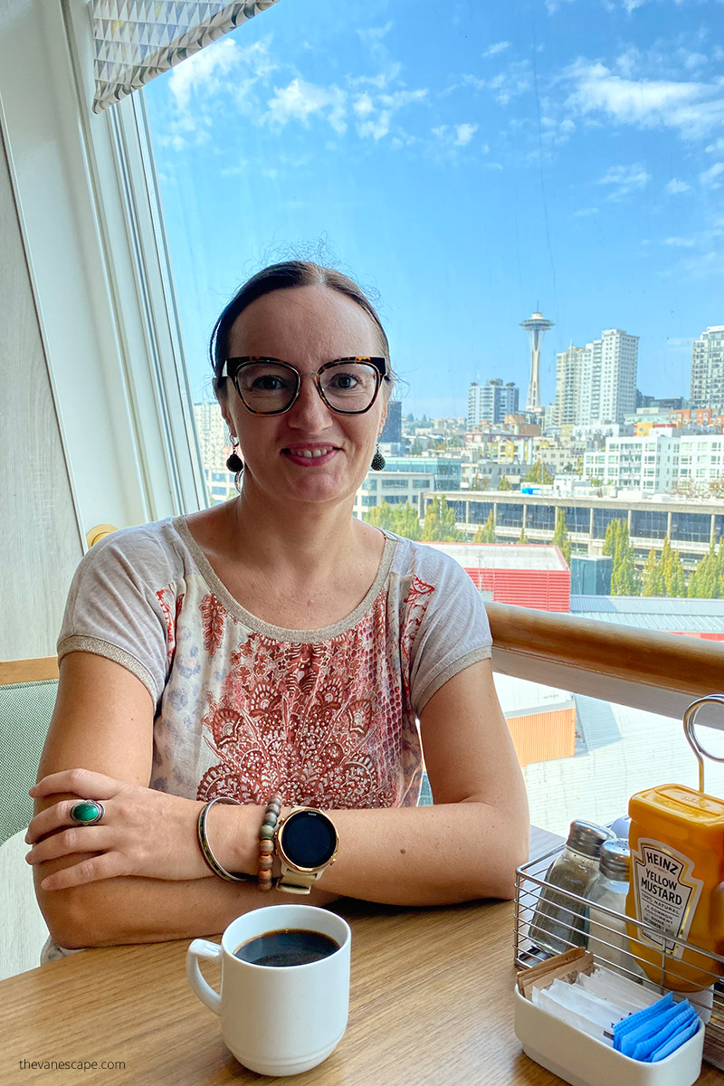 Agnes Stabinska, the author and co-founder of The Van Escape blog, is sitting in bar in Seattle with Space Needle in the backdrop.