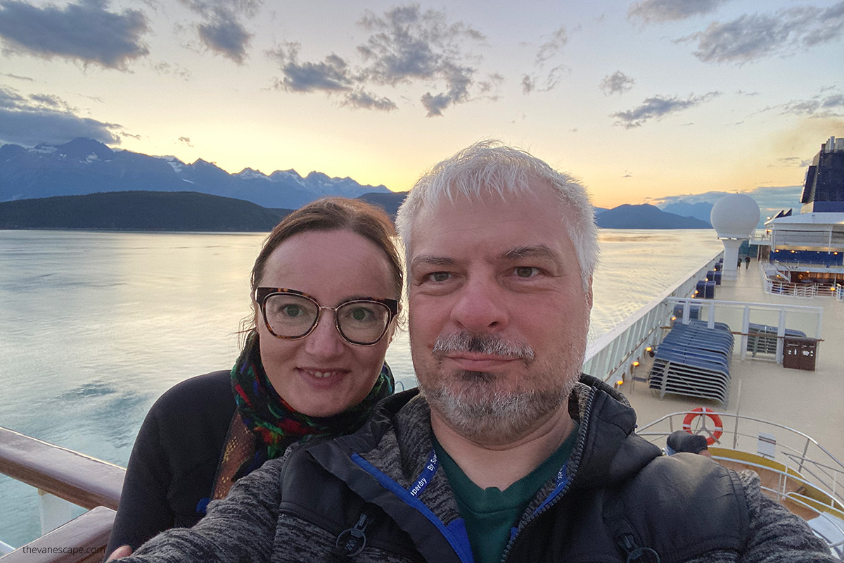 Agnes and Chris on Alaska cruise ship during sunset over sea and mountains