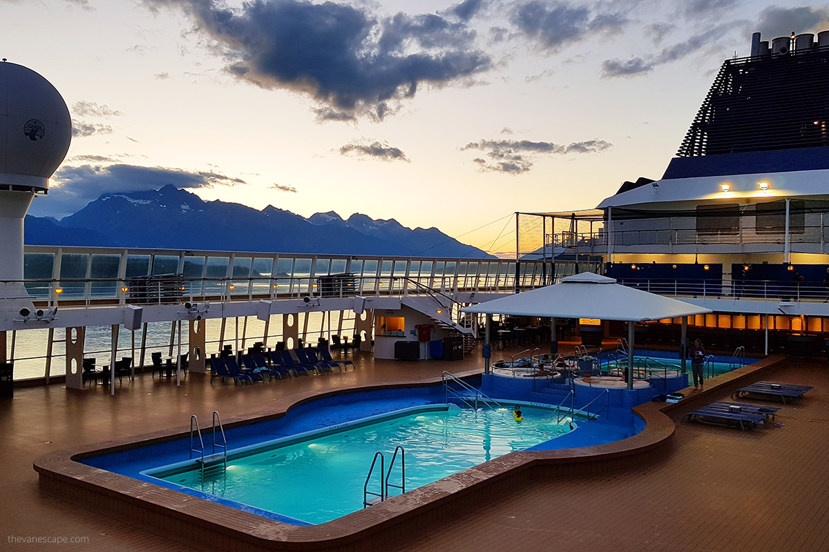 Norwegian Sun ship during Alaska cruise with huge swimming pool and mountains in backdrop