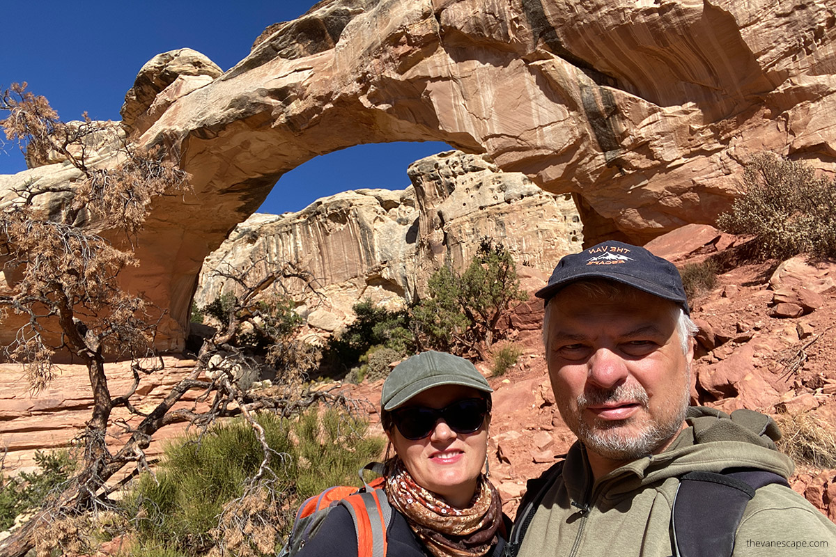 Agnes and Chris standing with huge Hickman Bridge - one of the arches in Capitol Reef.