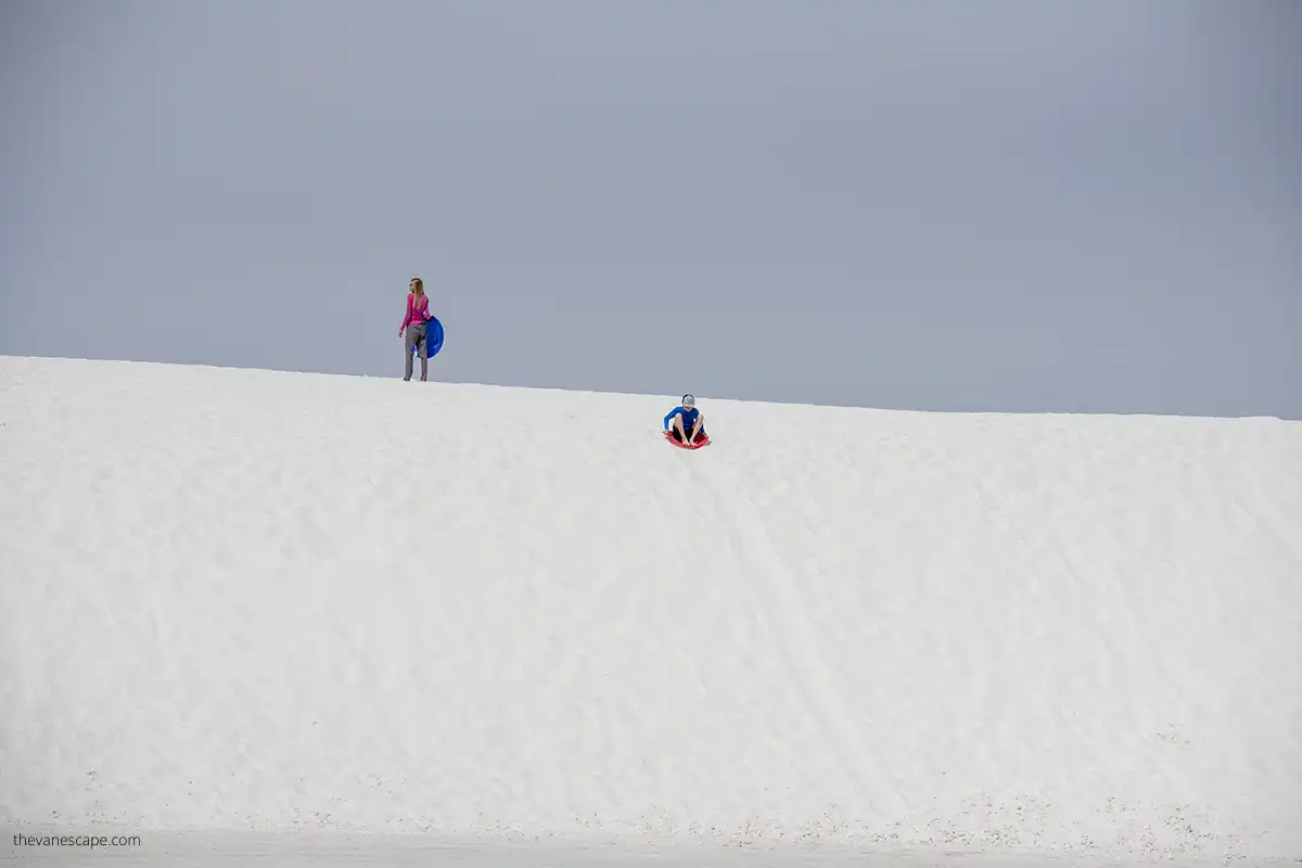 family fun on white dunes - sand sledding. 