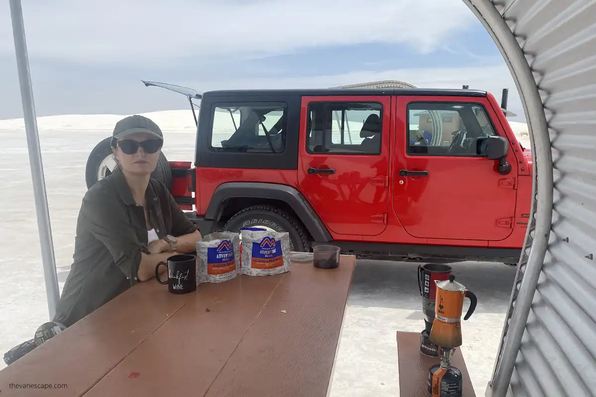 Agnes taking a break at one of White Sands' picnic areas - prepering camping meal and drinking coffee.