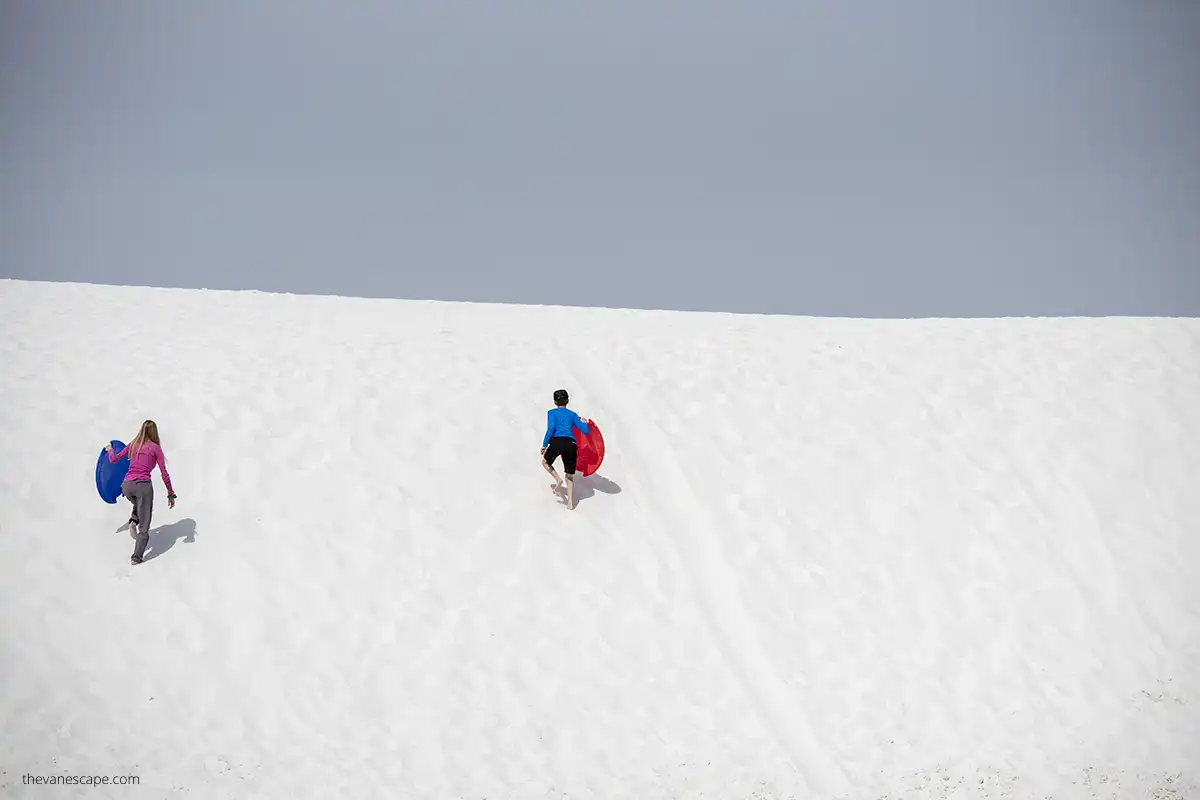 Family enjoy Sledding down the dunes - a must-do at White Sands.